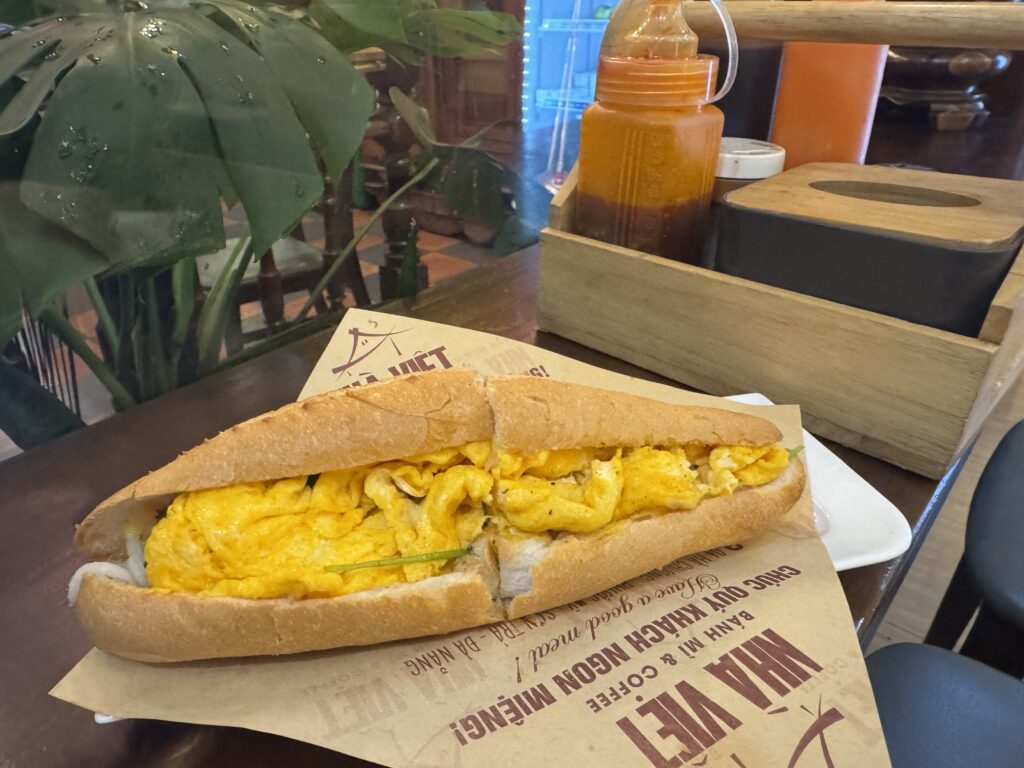 Egg Bánh Mì from Nhà Việt – served with a refreshing juice on a wooden tray