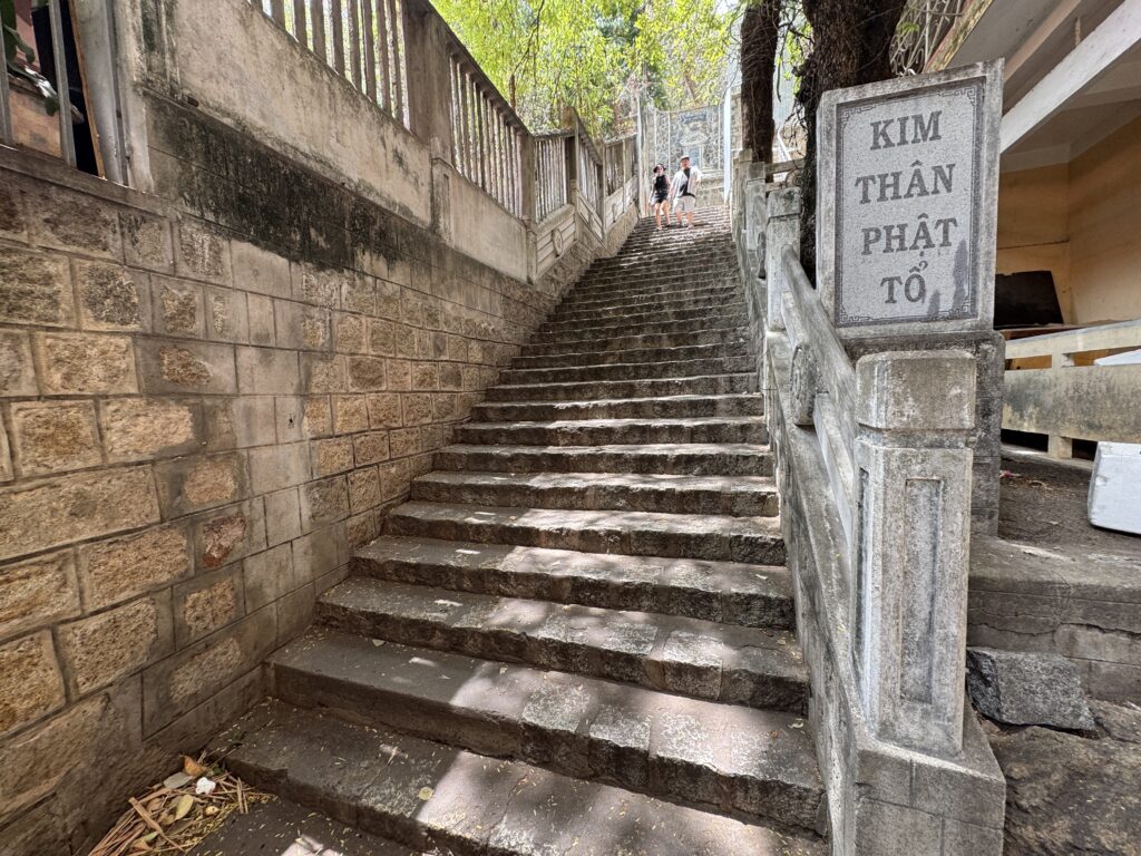 Stairway with sign leading to Buddha statue at Long Son Pagoda