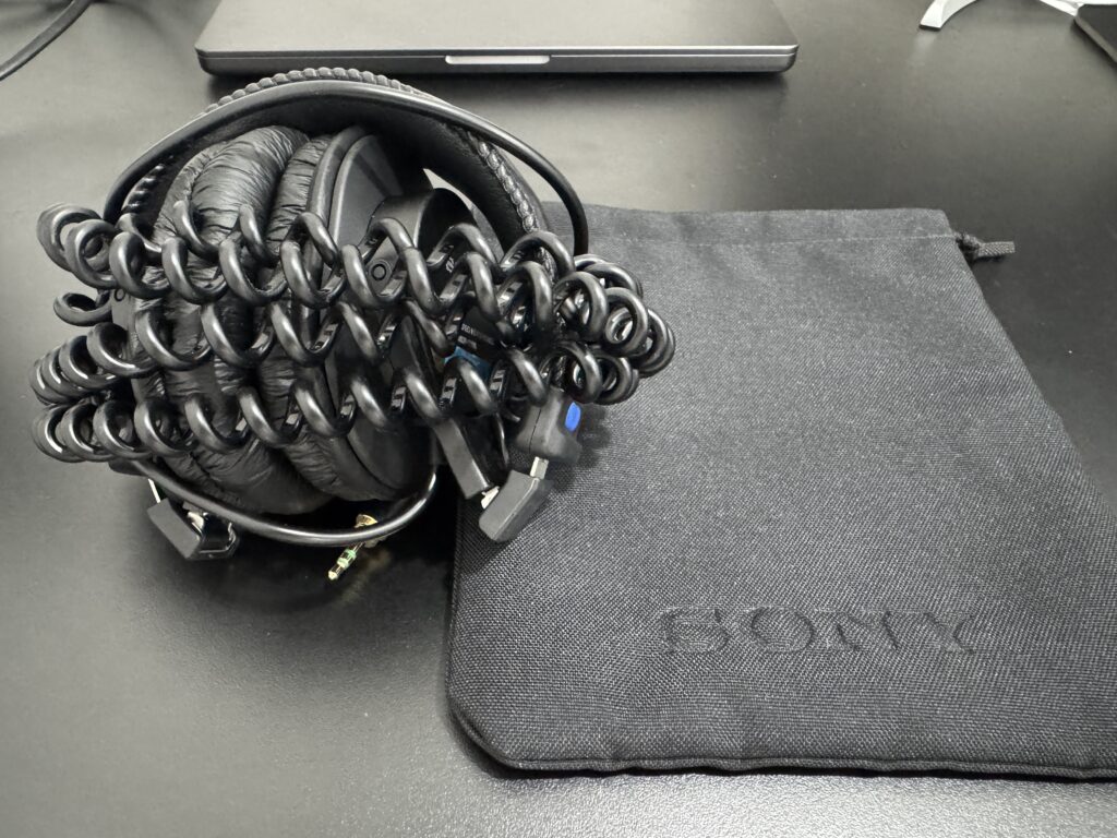 SONY MDR-7506の収納状態と付属ポーチ。カールコードをまとめた状態でポーチに収まっている様子